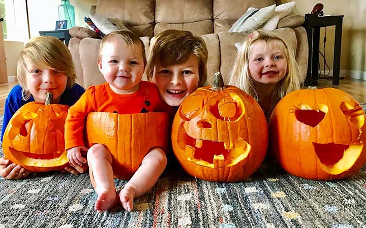 kids posing together with their Halloween pumpkins